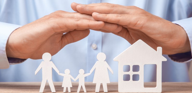 Canva Family insurance and home v2. Man in shirt covers his family with his father mother son and daughter and the house