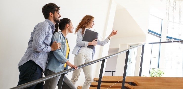 Canva Female Real Estate agent shows interior to young couple v3.